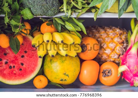 Opened refrigerator full of vegetarian healthy food, vibrant colour vegetables and fruits inside on fridge. Vegan Fridge.