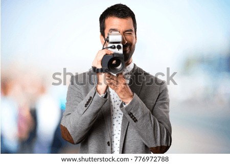 Handsome man filming on unfocused background