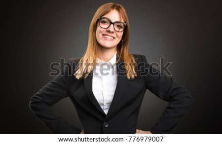 Happy young business woman on dark background
