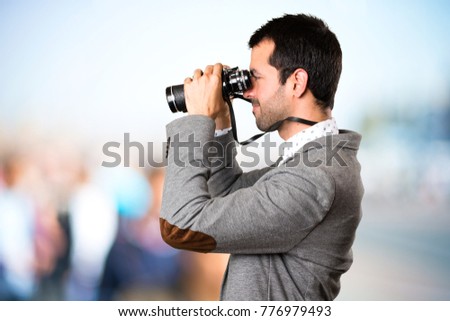 Handsome man with binoculars on unfocused background
