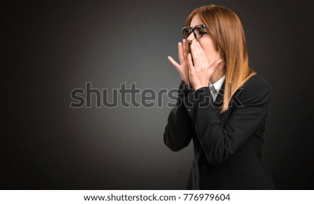 Young business woman shouting on dark background