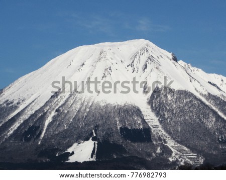Mountain Daisen covered with snow during winter with blue sky background in Tottori Prefecture, Japan.