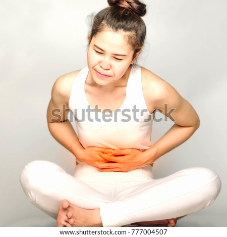 woman with stomachache. Female holding hand to spot of Abdomen. Concept photo with read spot indicating location of the pain.