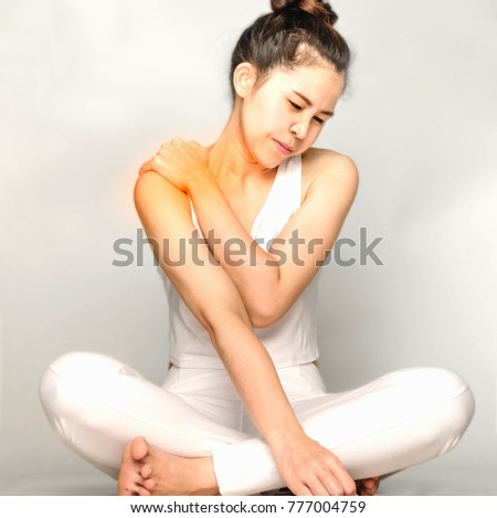 woman with shoulder pain or neck pain.Acute pain in a woman Throat . Female holding hand to spot of nape-aches. Concept photo with read spot indicating location of the pain.