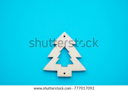 Wooden Christmas tree shape on blue paper background with copy space