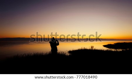 Young women taking picture of Golden hour at the beach