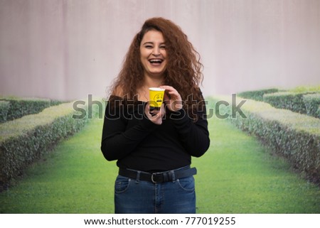 
beautiful girl enjoying the green background, curly girl drinking coffee