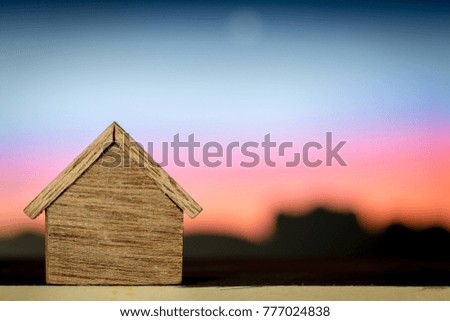 A wooden home put on the wood in the sunset view background, loan for buying a new house and investment with real estate concept.