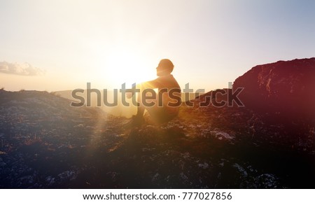 Man at sunset mountains Royalty-Free Stock Photo #777027856