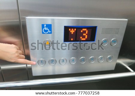 Asian woman pressing the disabled elevator button of the elevator. Soft focus.

