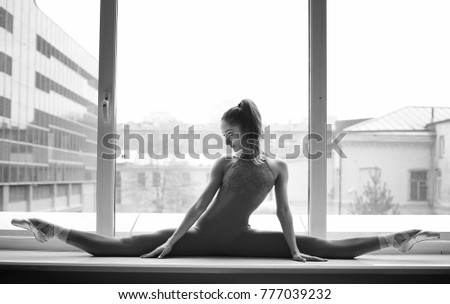 young ballerina posing in the window