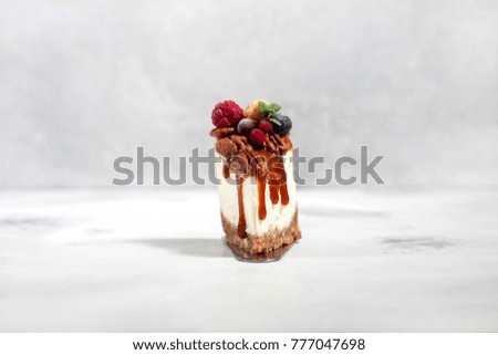 A piece of Cheesecake with pecans and caramel sauce on a light background