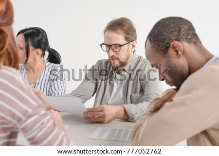 cropped shot of four multiethnic business people working with papers together