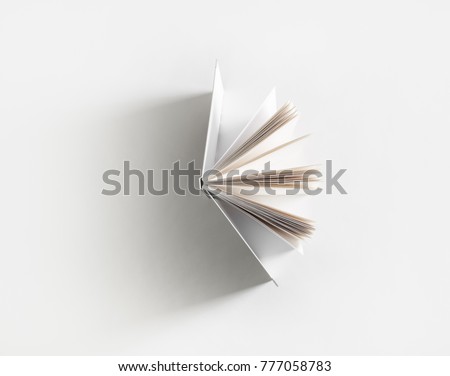 Open book with soft shadow on white paper background.