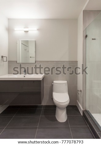 Modern bathroom with gray wall hanged vanity and full size vanity sink and glass shower door Royalty-Free Stock Photo #777078793