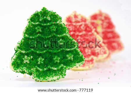 Row of Christmas Cookies with a pair of red trees behind