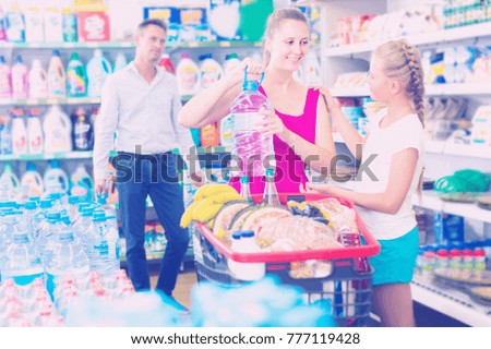 Young family with kid are choosing goods in shop.