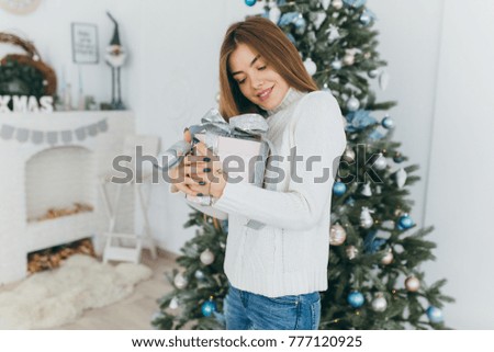 A beautiful girl unpacks Christmas gifts.
