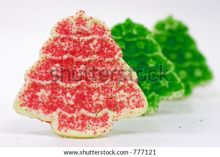 Row of Christmas cookies shaped like trees with a red tree in front