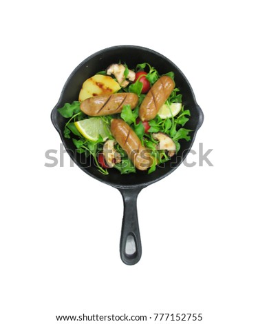 chicken sausage and salad  decorate with lemon, tomato, potato, vegetable, mushroom. Every thing on black pan. In kitchen room or restaurant.
