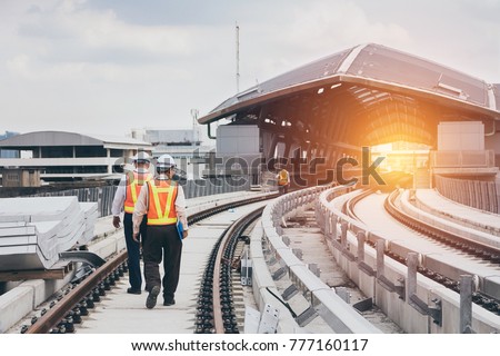 Inspector (Engineer) checking railway construction work on skytrain viaduct. Which railway consist of rail track and conductor rail or third rail. Royalty-Free Stock Photo #777160117