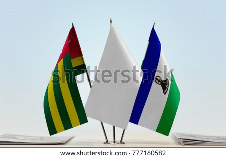 Flags of Togo and Lesotho with a white flag in the middle