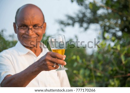 Seiner cheerful man holding a glass of alcohol in his hand, ready to drink it.