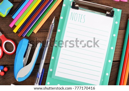The clipboard with sheets and colored pencils