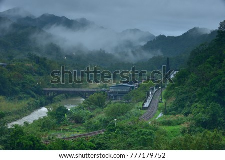 New Taipei City Taiwan's summer, foggy valley, rural simplicity of the evening, the panorama picture of the train passing through the farmland.
