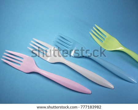 Colorful fork on blue paper texture background.