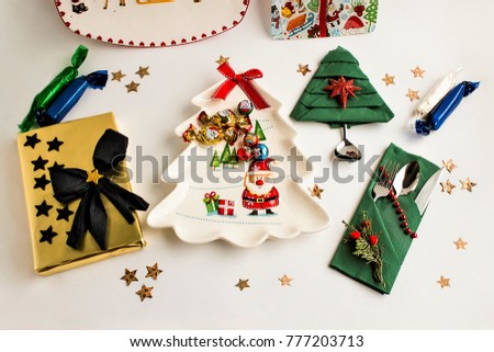 Christmas Table with gifts,plate and cutlery set in napkin,above view
