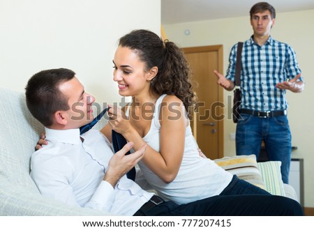 Upset young man coming home and seeing girlfriend cheating on him
 Royalty-Free Stock Photo #777207415