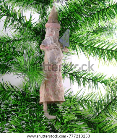 handmade papier-mache Santa Claus in green Christmas tree