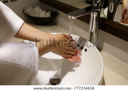 Washing of hands under the crane with water