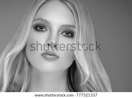 Young beautiful woman face portrait with healthy skin over dark background. Studio shot.