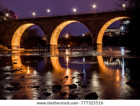 Long exposure night time twilight blue hour shot of Stone Arch Bridge Minneapolis Minnesota on the Mississippi River
