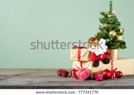 Christmas background. Little Christmas tree with decorations on a dark wooden table. Green background. Space for text. New Year's background.