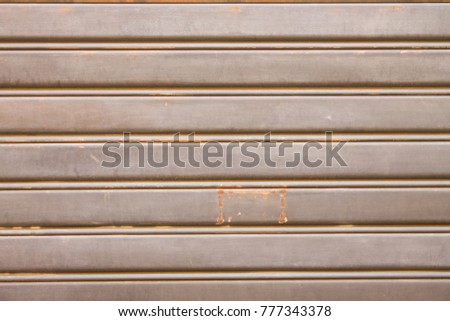Brown rolling shutter with some red rust sign