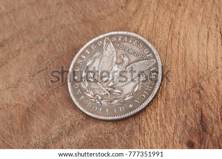 antique silver dollar on wooden background