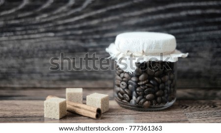 Coffee beans on a wooden table and in a glass jar