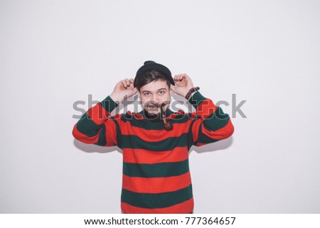 boy wearing bobble hat and smoking tobacco pipe