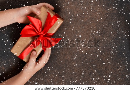New Year card. A box with gifts in the hands of the child.