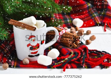 A cup of hot winter drink with marshmallow and cinnamon. New Year's background.
