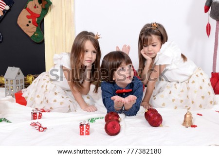 Happy kids play with decorations for Christmas evening