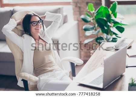 Nice, independent, cute woman in white suit, formal wear, glasses sitting on chair at her desk in office, holding arms behind the head with close eyes, thinking about holidays, vacation Royalty-Free Stock Photo #777418258