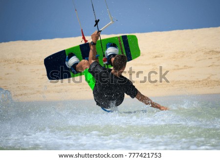 Kite surfer rides ideal flat water of the lake lagoon with kite flying in sky making slide trick. Recreation activity and active extreme water sports kiteboarding, hobby and fun in vacation time