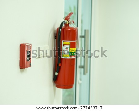Fire alarm pull station(Manual fire alarm activation) and red fire extinguisher installed at the walkway in the office.