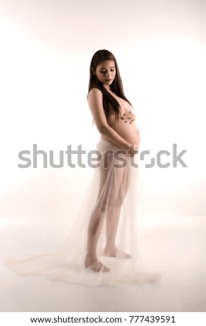 young women pregnant post stand side view and touch womb isolated  white  background , sipia tone image portrait