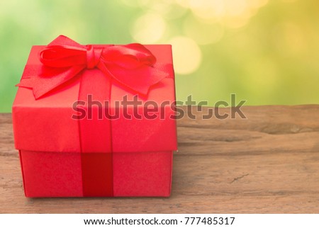 red gift box on old wood bokeh background.