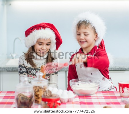 Brother and sister cooking Christmas cookies at home